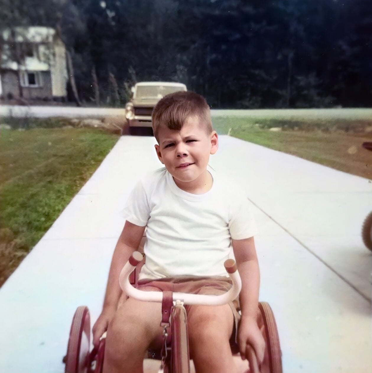 Robert Brighton as a child on a tricycle